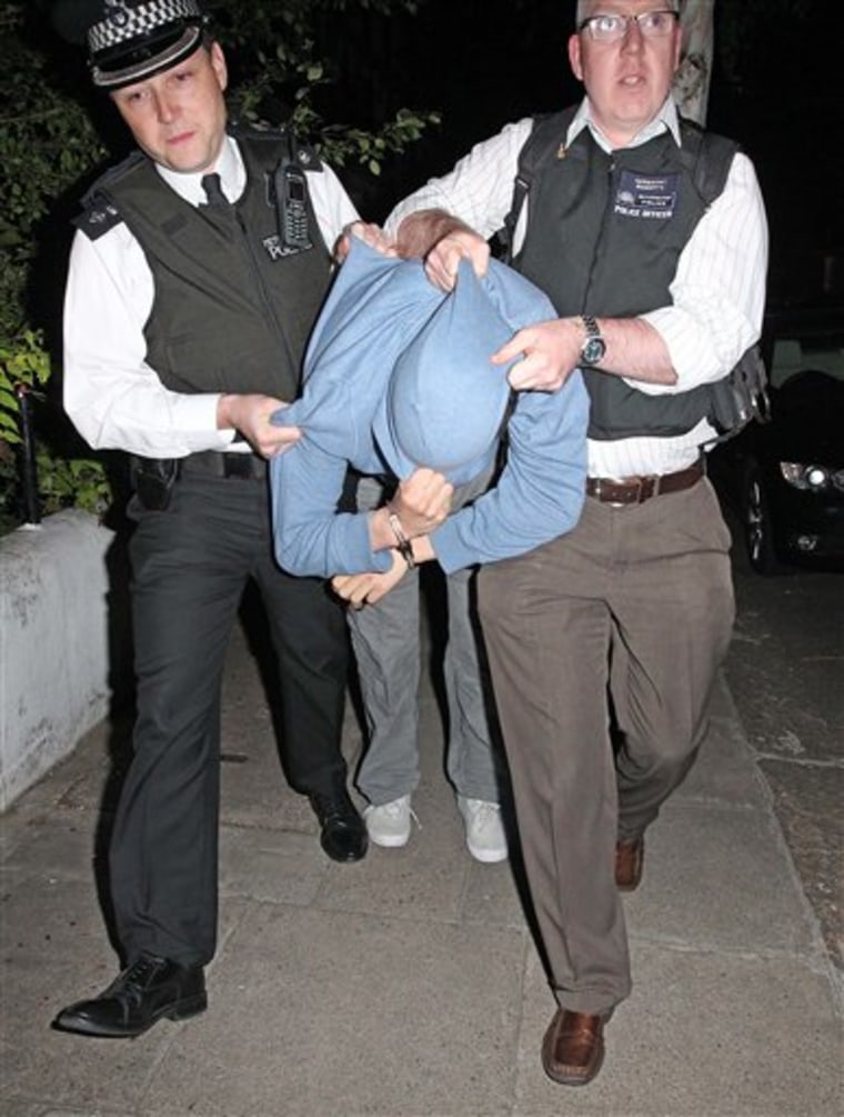 Chief Superintendent Simon Ovens, left, commander of the Westminster Burglary Squad, and another officer apprehend a suspect following a raid by police in an attempt to recover property stolen during the recent civil disturbances. Britain's Prime Minister David Cameron promised vigorous and wide-ranging measures to restore order and prevent riots erupting again on Britain's streets - including taking gang-fighting tips from American cities.  Cameron told lawmakers there would be no \"culture of fear\" on Britain's streets, as police raided houses to round up more suspects from four days of rioting and looting in London and other English cities.(AP Photo/Nigel Howard/Evening Standard, pool)